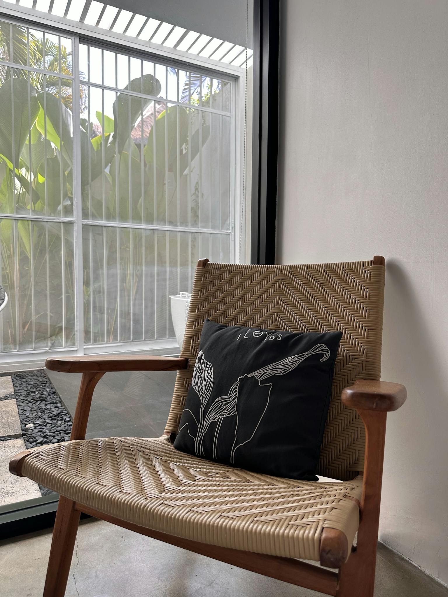 Minimalist interior with a rattan chair and pillow in a bright room, Bali, Indonesia.