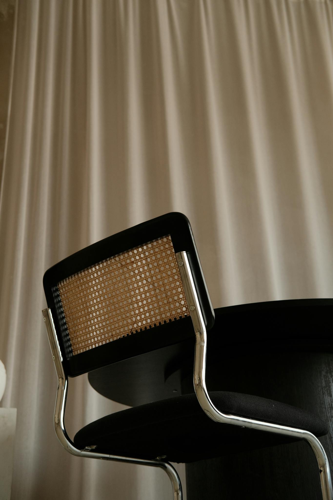Stylish minimalist interior featuring a rattan chair and modern table.